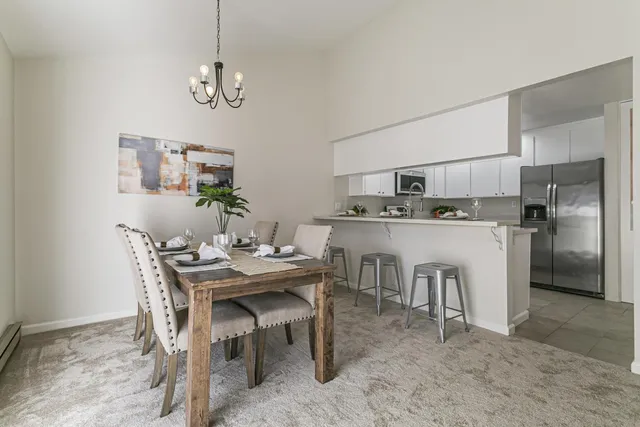a dining room with stainless steel appliances kitchen island a table and chairs