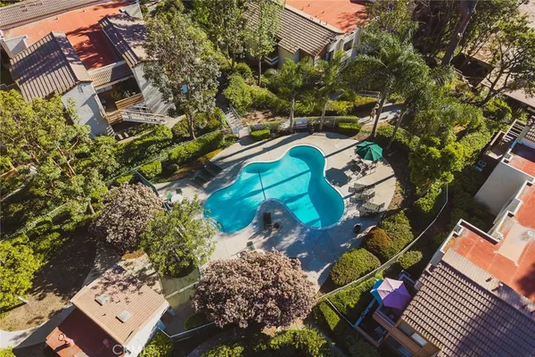 a view of swimming pool with a backyard and trees
