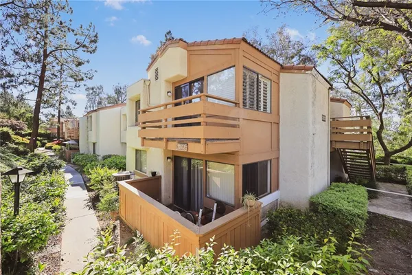 a large tree in front of a white house