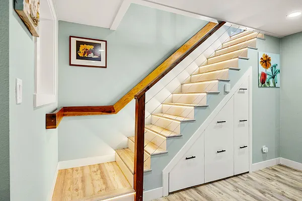 a large white kitchen with granite countertop a stove a sink a window and white cabinets