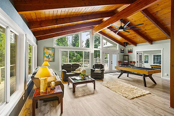 a living room with furniture a flat screen tv and a large window