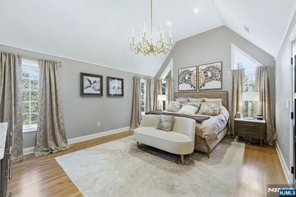 a spacious bedroom with a bed and a chandelier