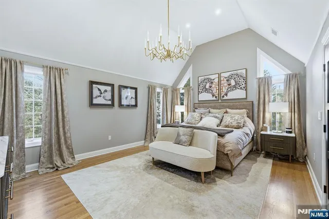 a spacious bedroom with a bed and a chandelier