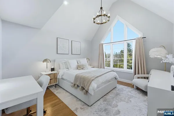 a bedroom with a bed and a chandelier
