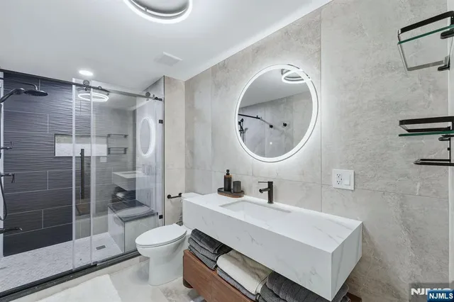 a bathroom with a sink mirror toilet and shower