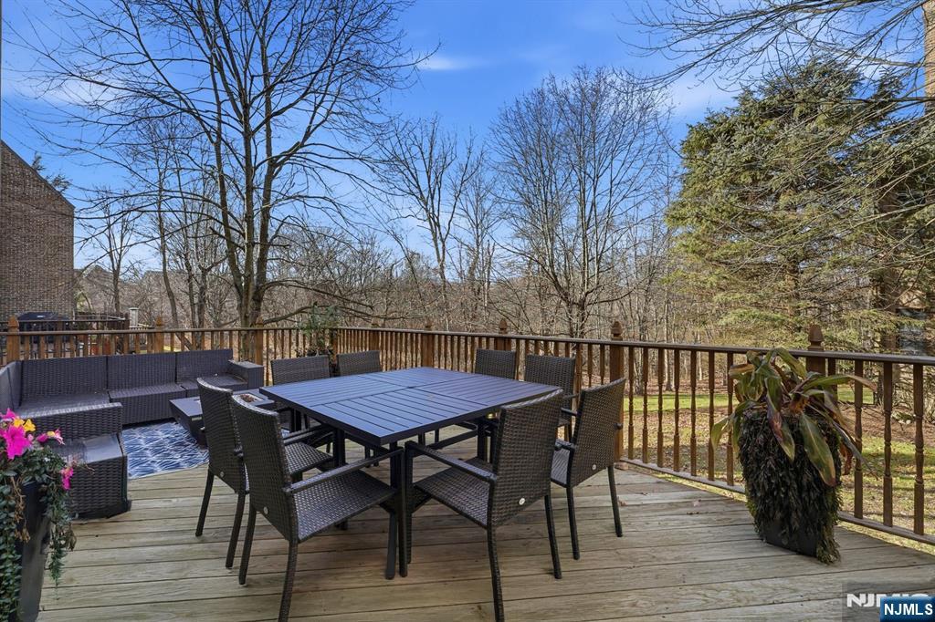 204 Bearwoods Road Park Ridge, NJ 07656 - Photo 33 of 39 a view of a roof deck with table and chairs with wooden floor and fence