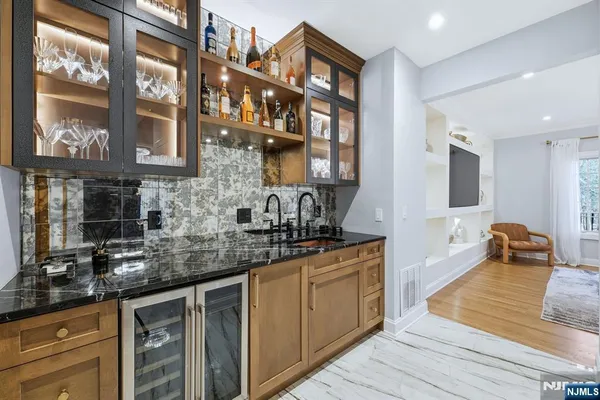 a kitchen with stainless steel appliances granite countertop a sink and wooden cabinets