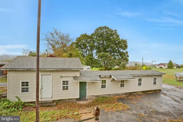 a view of a house with a yard and large tree