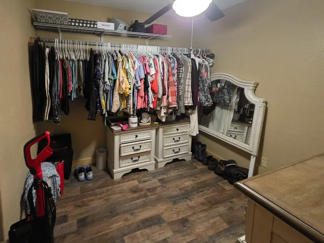 a view of walk in closet with clothes and shoes