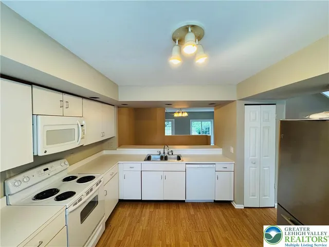 a kitchen with stainless steel appliances a sink a stove a refrigerator and cabinets