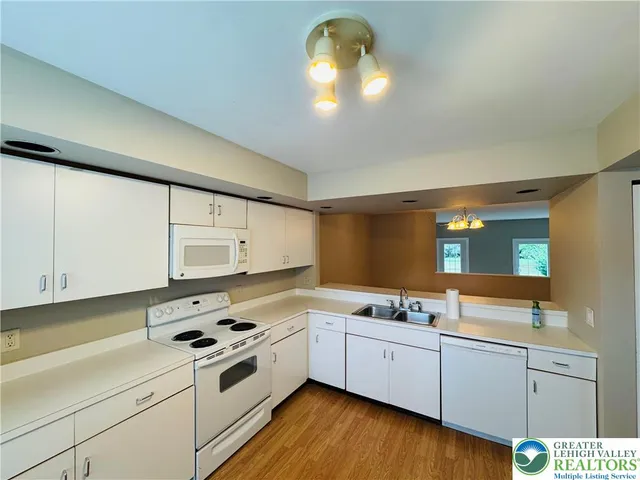 a kitchen with stainless steel appliances a white stove top oven sink and cabinets
