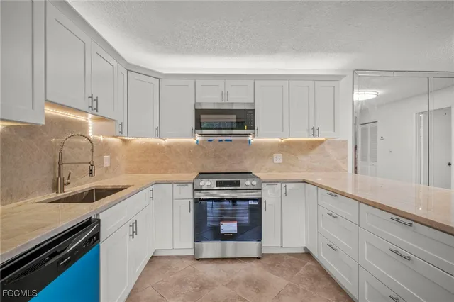 a kitchen with sink a stove and cabinets
