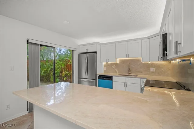 a kitchen with granite countertop a sink and white cabinets