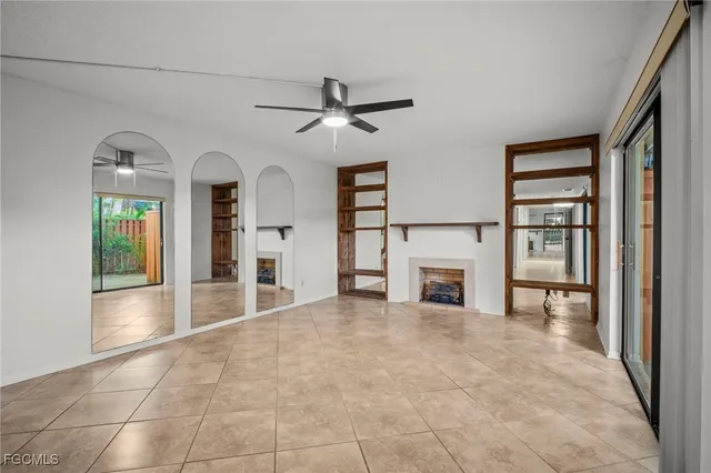 an empty room with windows and fireplace