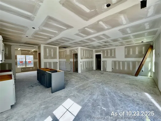 a living room with furniture and a refrigerator