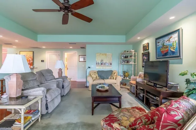 a living room with furniture ceiling fan and a window