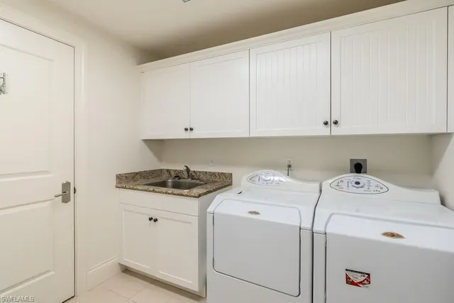 a bedroom with a bed a chandelier and a flat screen tv