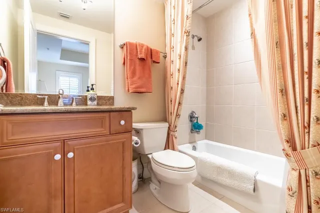 a bathroom with a granite countertop sink a toilet and bathtub