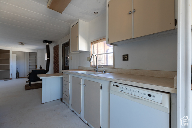 6026 East Zion Road Kanab, UT 84741 - Photo 14 of 27 Kitchen featuring dishwasher, sink, kitchen peninsula, and a wood stove