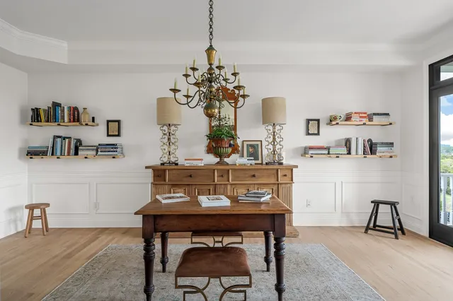 a kitchen with stainless steel appliances kitchen island granite countertop a stove a sink and white cabinets with wooden floor