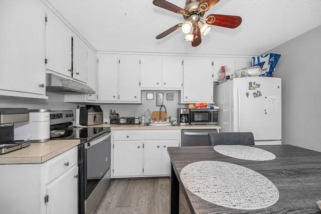 a kitchen with stainless steel appliances granite countertop a sink dishwasher stove and refrigerator with cabinets