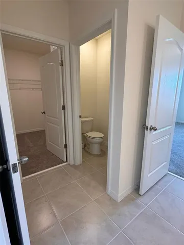 a bathroom with a granite countertop shower and a toilet