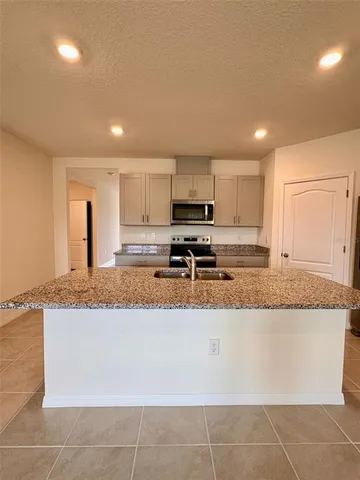 a large kitchen with granite countertop a granite counter tops and white cabinets