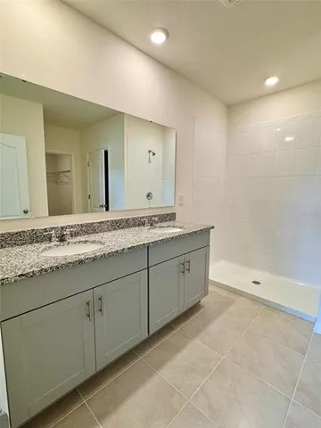 a spacious bathroom with a granite countertop sink a mirror and a