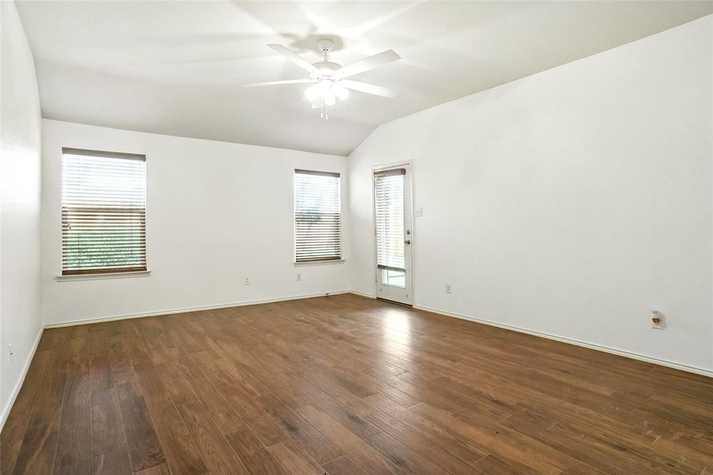 9907 Divine Court Frisco, TX 75033 - Photo 14 of 31 Spare room featuring lofted ceiling, dark wood-style flooring, and ceiling fan