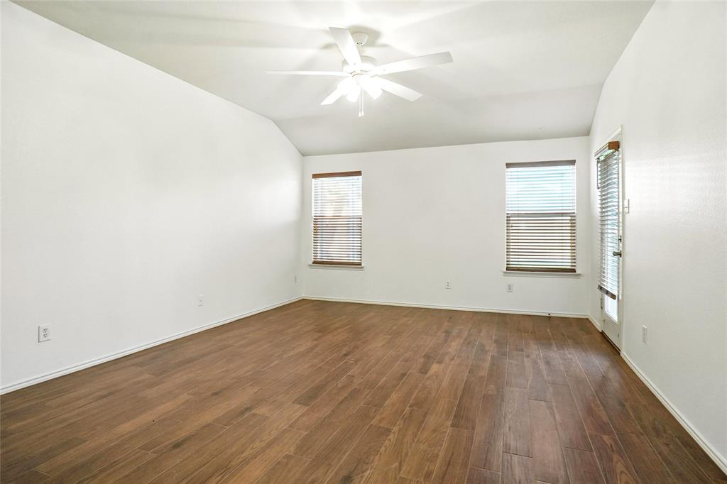 9907 Divine Court Frisco, TX 75033 - Photo 16 of 31 Unfurnished room featuring vaulted ceiling, healthy amount of natural light, dark wood finished floors, and a ceiling fan
