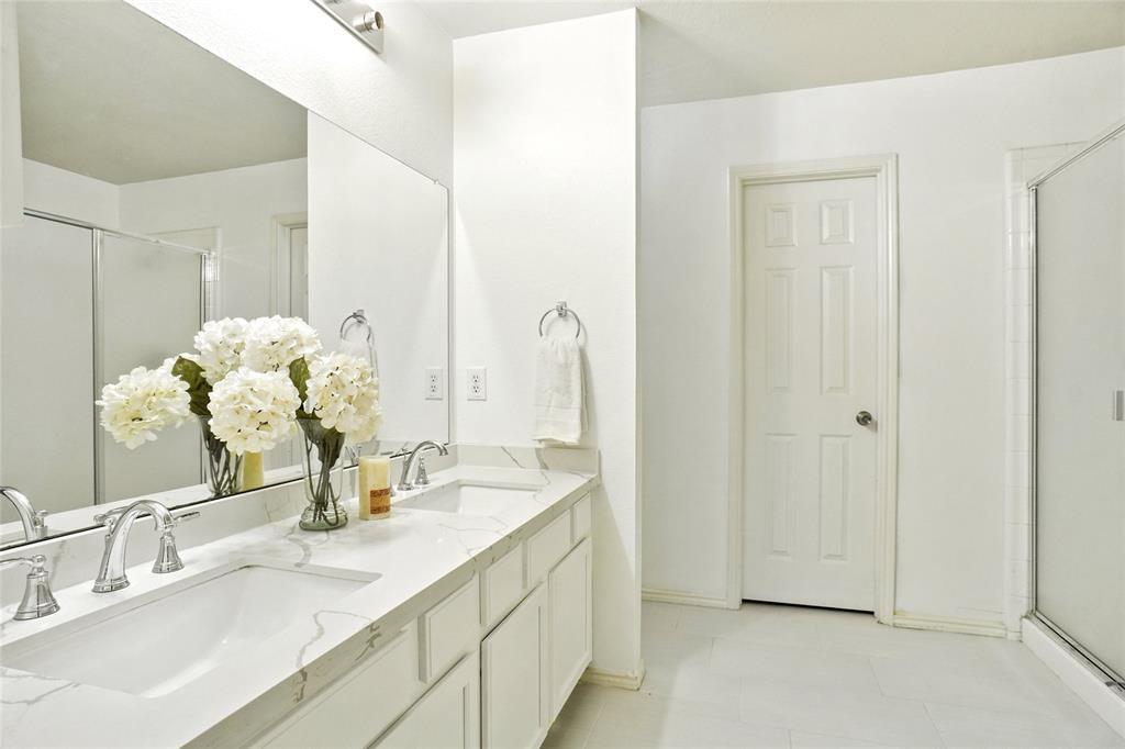 9907 Divine Court Frisco, TX 75033 - Photo 17 of 31 Bathroom featuring a shower stall, double vanity, and light tile patterned floors