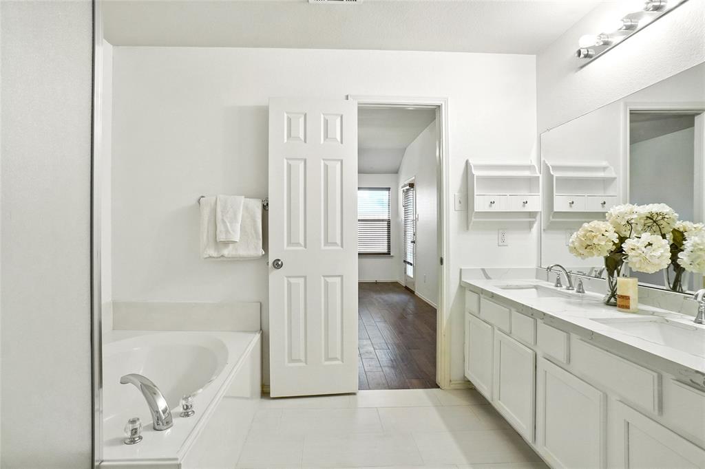 9907 Divine Court Frisco, TX 75033 - Photo 19 of 31 Full bath featuring double vanity, a garden tub, and light tile patterned flooring