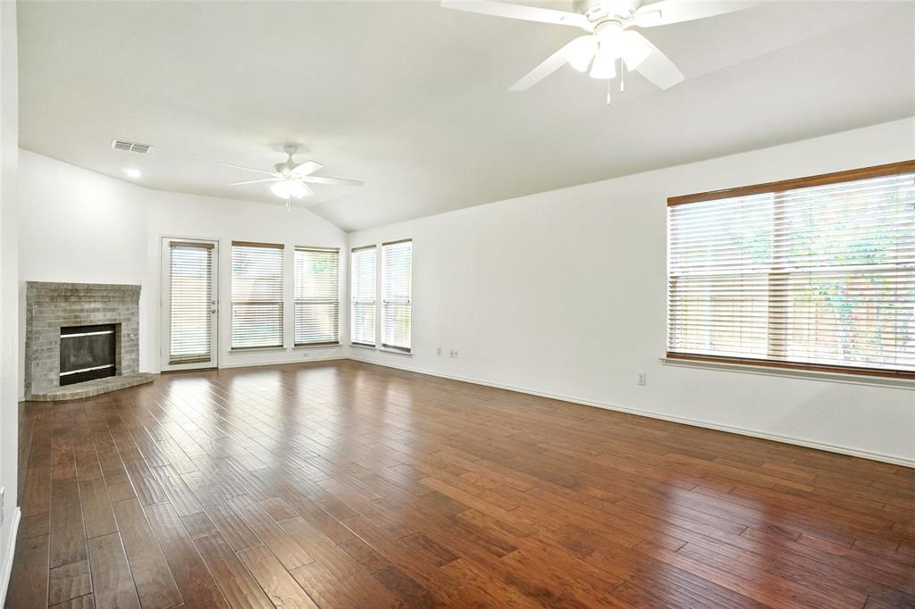 9907 Divine Court Frisco, TX 75033 - Photo 4 of 31 Unfurnished living room with dark wood-style flooring, plenty of natural light, and vaulted ceiling