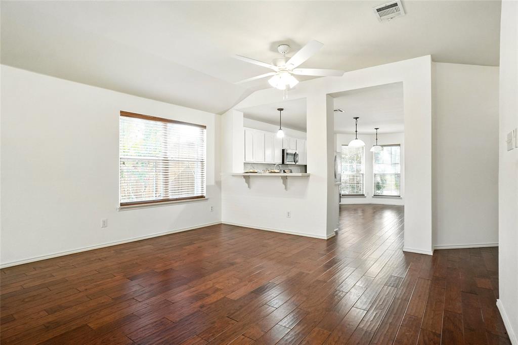 9907 Divine Court Frisco, TX 75033 - Photo 7 of 31 Unfurnished living room with dark wood-style flooring and ceiling fan
