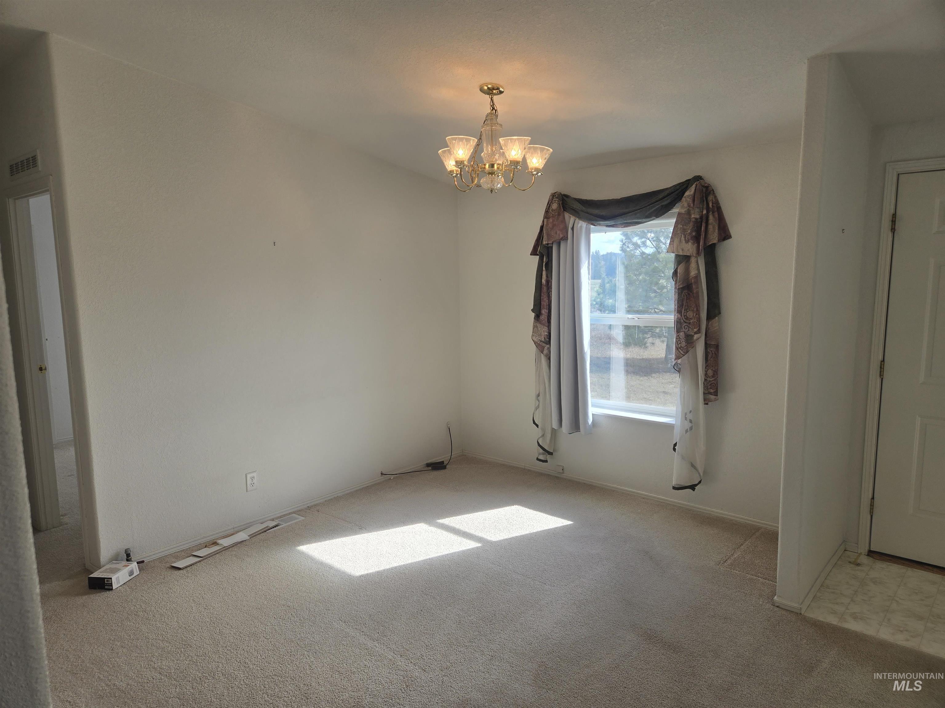 135 Harrisburg Road Kamiah, ID 83536 - Photo 5 of 30 Unfurnished dining area featuring hanging lights and light carpet