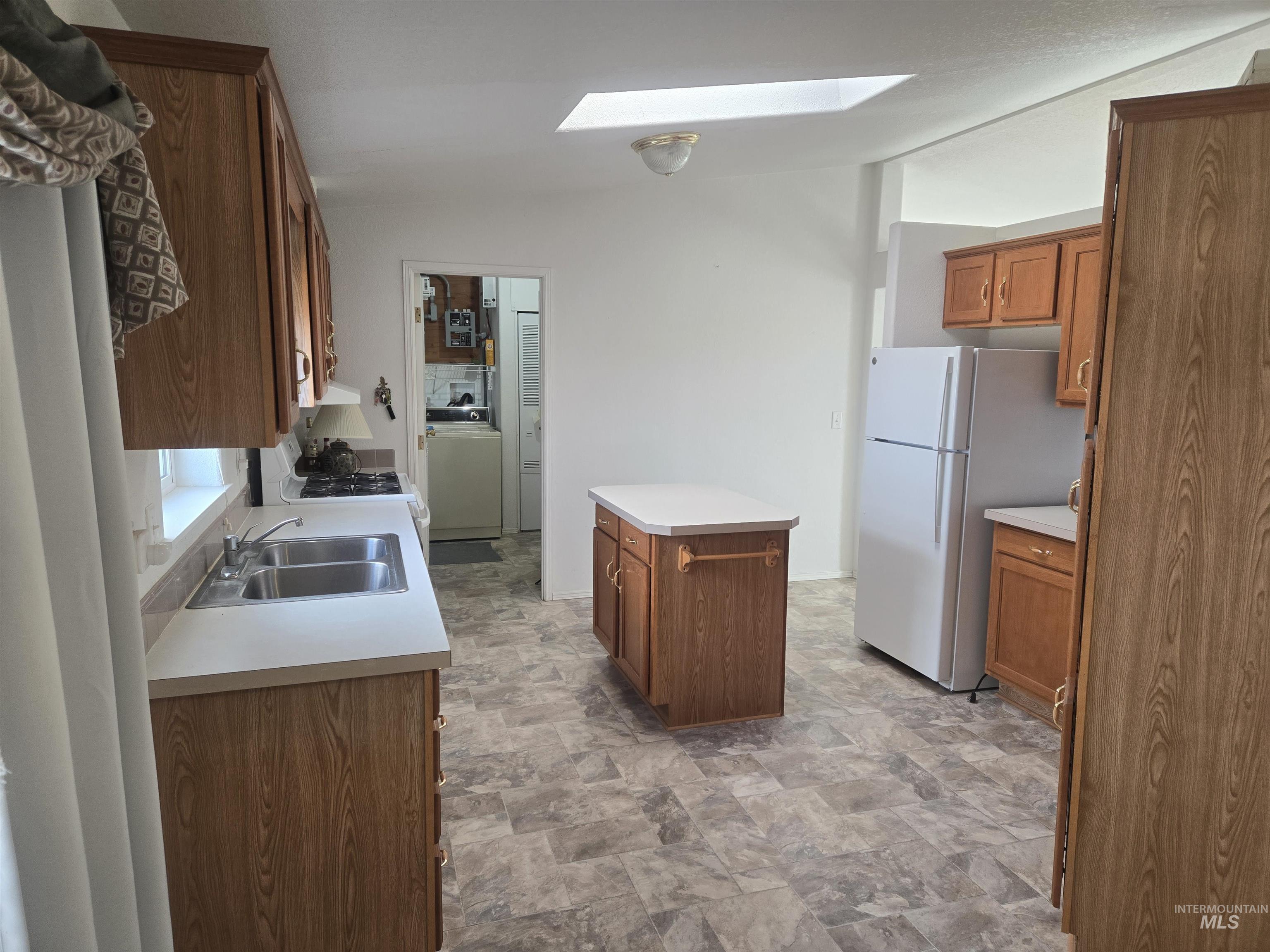 135 Harrisburg Road Kamiah, ID 83536 - Photo 6 of 30 Kitchen with stone finish floors, wood finish cabinetry, freestanding refrigerator, light countertops, and lofted ceiling
