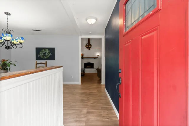 a view of a hallway with wooden floor and stairs