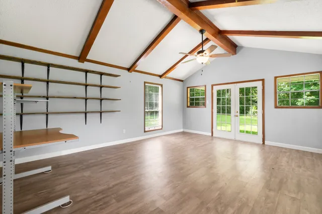 a view of a livingroom with wooden floor and a ceiling fan