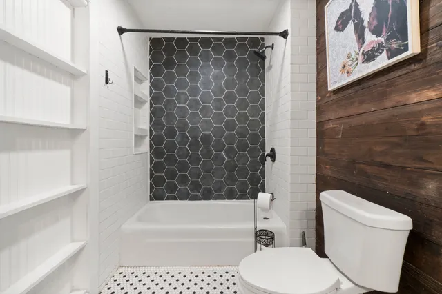 a spacious bedroom with a bed and a flat screen tv