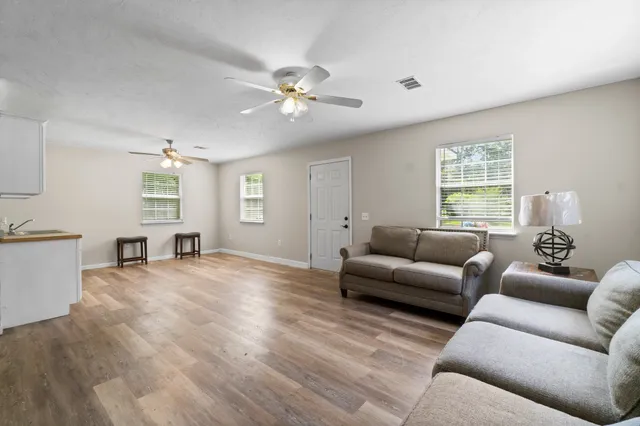 a view of a kitchen with sink microwave and cabinets