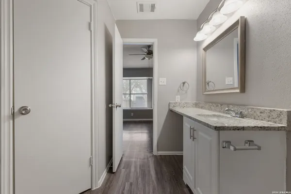 a en suite bathroom with a granite countertop sink and a mirror
