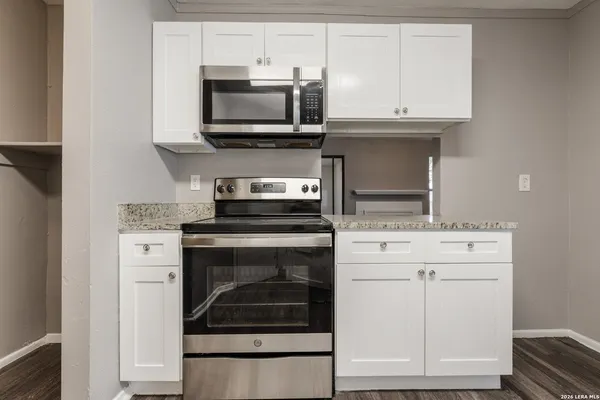 a kitchen with stainless steel appliances granite countertop a stove microwave and cabinets