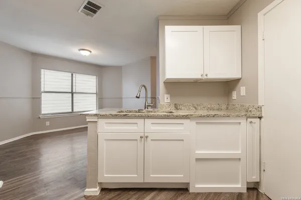 a kitchen with cabinets appliances a sink and a window
