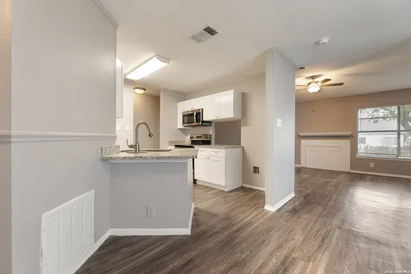 a kitchen with a refrigerator and white cabinets