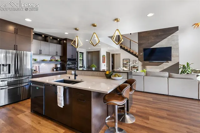 a kitchen with stainless steel appliances granite countertop a sink a stove and a refrigerator
