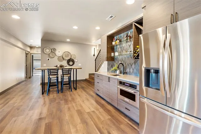 a kitchen with stainless steel appliances granite countertop a refrigerator and a stove top oven