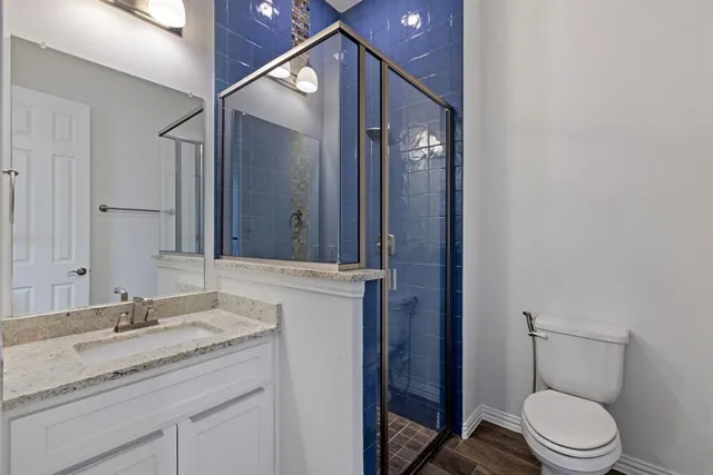 a bathroom with a granite countertop sink toilet and shower