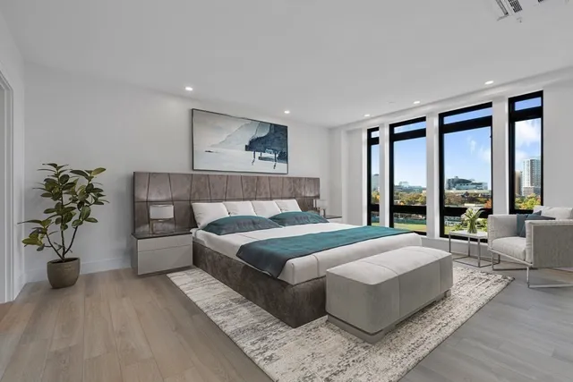 a bedroom with a large bed and a potted plant