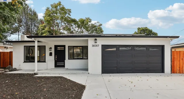 front view of a house with a yard and garage