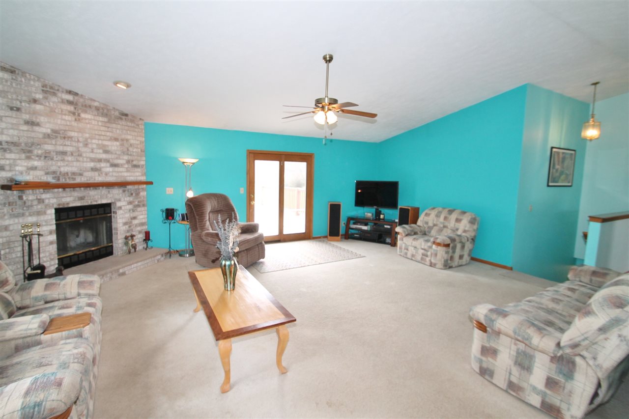 4247 Waltham Road Roscoe, IL 61073 - Photo 5 of 19 a living room with furniture a fireplace and a chandelier